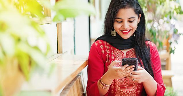 A woman on her smartphone smiling.